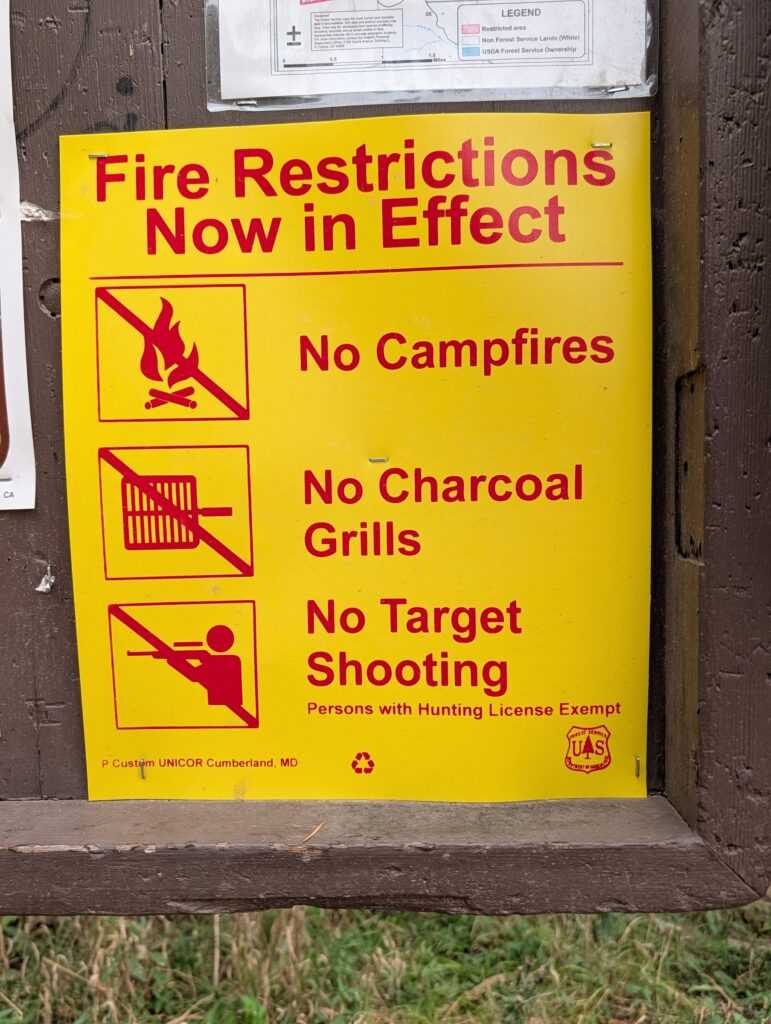 A yellow notice: Fire Restrictions Now in Effect, No Campfires, No Charcoal Grills, No Target Shooting, persons with hunting license exempt.