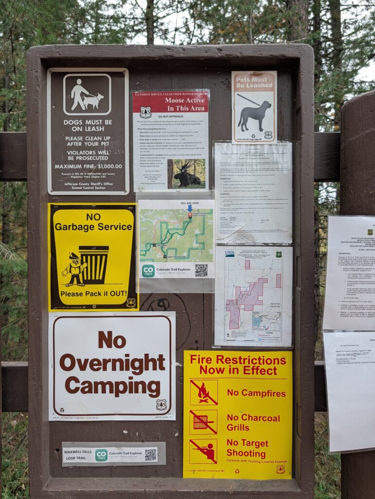 The lower trailhead kiosk with a leash-law sign, moose warning, no garbage service sign, fire restrictions and a COTREX trail map.